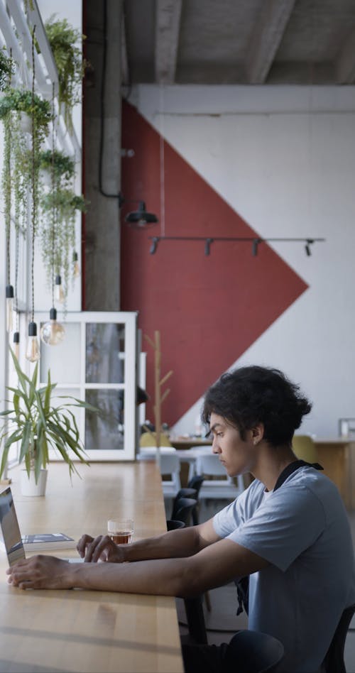 Un Homme à L'aide De Son Ordinateur Portable à L'intérieur D'un Café