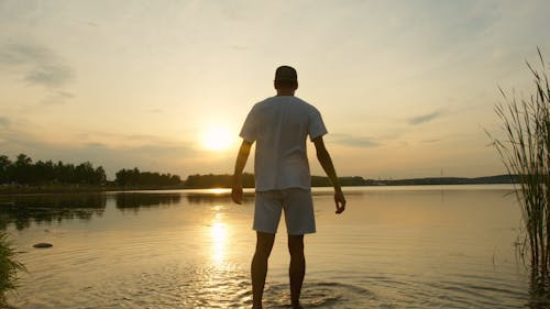 A Man Walking On The Lakeside Water