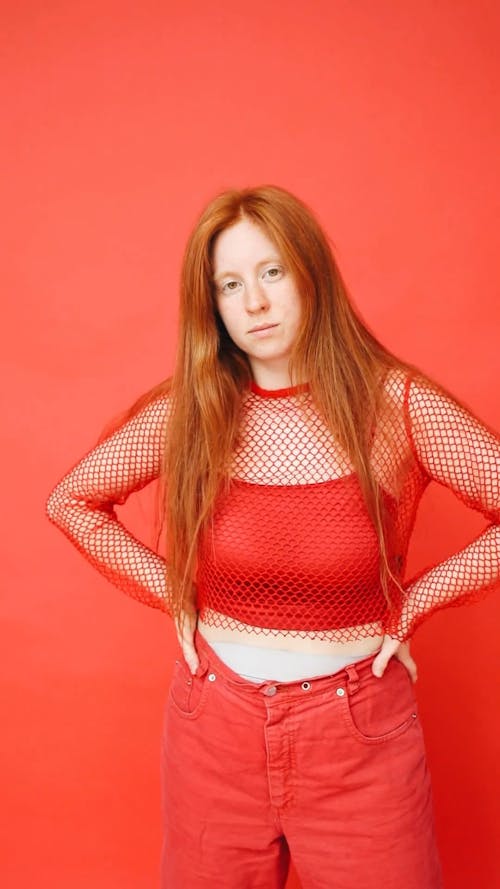 Woman in Red Fishnet Crop Top Doing Akimbo Pose