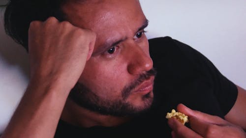 Man in Black Shirt Eating Popcorn