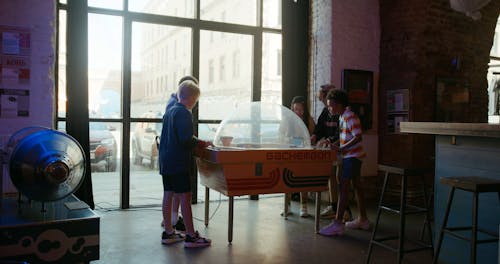 A Group Of Kids Playing In An Arcade