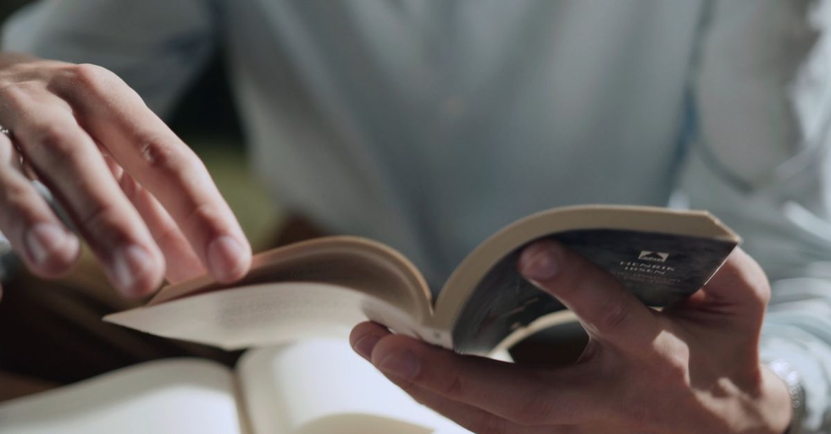 Using Mobile While Reading A person is reading a book while holding a cell phone Free Stock Video ...