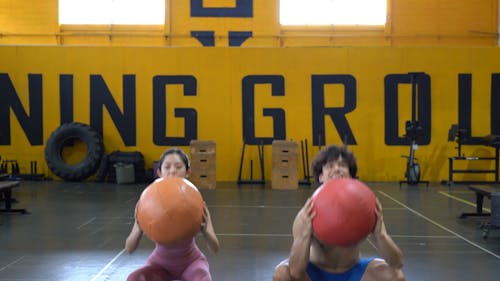 Man and Woman Exercising With Medicine Ball