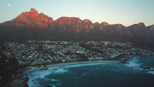 Drone Footage of Coastal Landscape Against Mountain Background