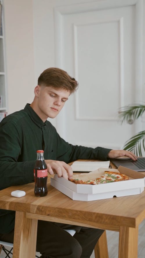 Man Eating Pizza While Working