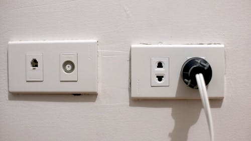Plugging An Electrical Equipment On The Wall Socket