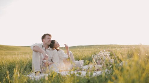 Couple Having a Picnic in Grass Field