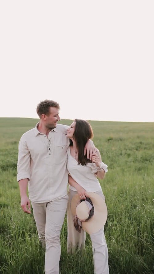 Couple Walking on Grass Field