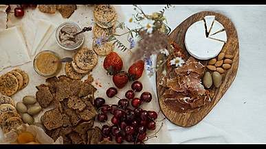 a person is holding a plate of food and a plate of fruit