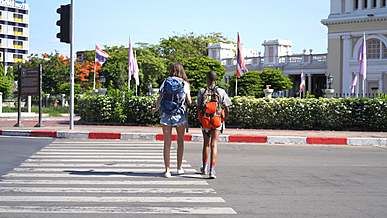 female backpackers crossing a road