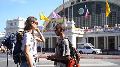 two female backpackers talking on the street side