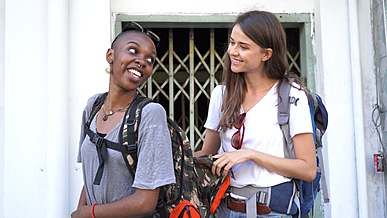 a woman looking at the inside of her friend s backpack