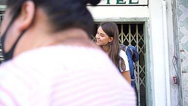 a woman looking for something at her friend s backpack