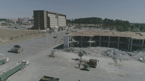 An Aerial Footage of a Building and a Wrecked Building