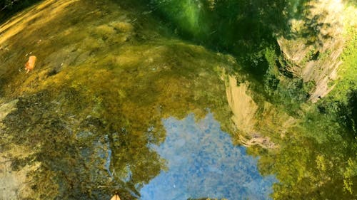 Reflection Of The Mountain Cliff From A Lake Below