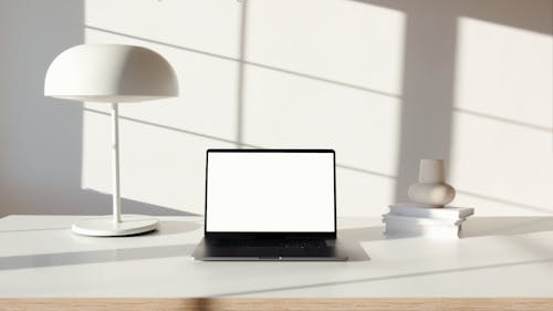 Laptop Computer on White Surface Near White Lampshade