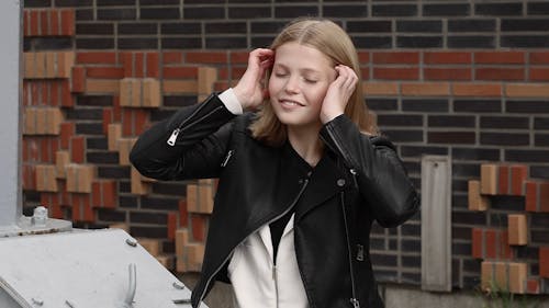 Woman in Black Leather Jacket Fixing Her Hair