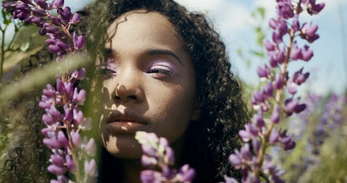 A Young Woman Posing Along Flowers In The Field