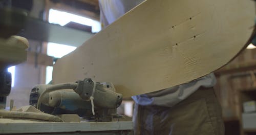 A Craftsman Smoothing a Skateboard