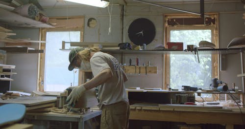 Craftsman Smoothing a Skateboard in Progress