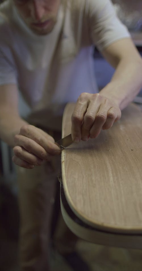 A Craftsman Carving a Skateboard in Progress