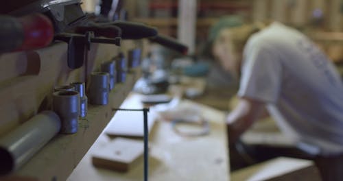 A Man Working In A Workshop Making Skateboards