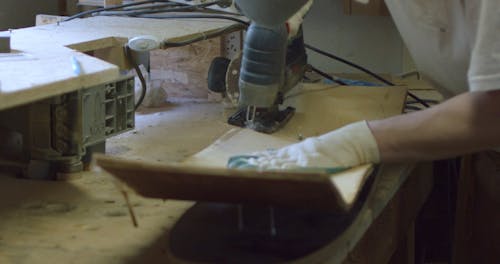 A Craftsman Using a Circular Saw in Making a Skateboard