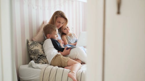 A Mother Watching On a laptop With Her Kids