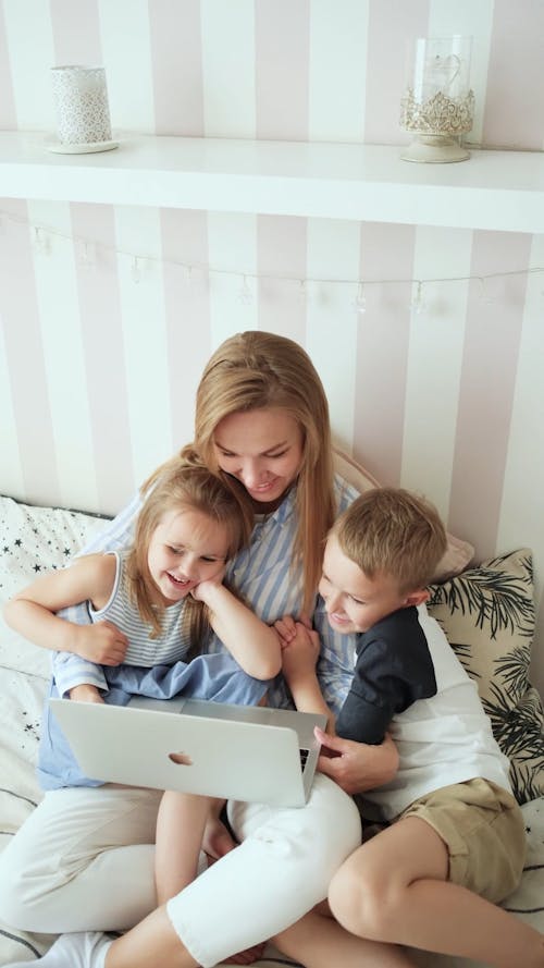 Kids Staying With Their Mom Watching On A Laptop