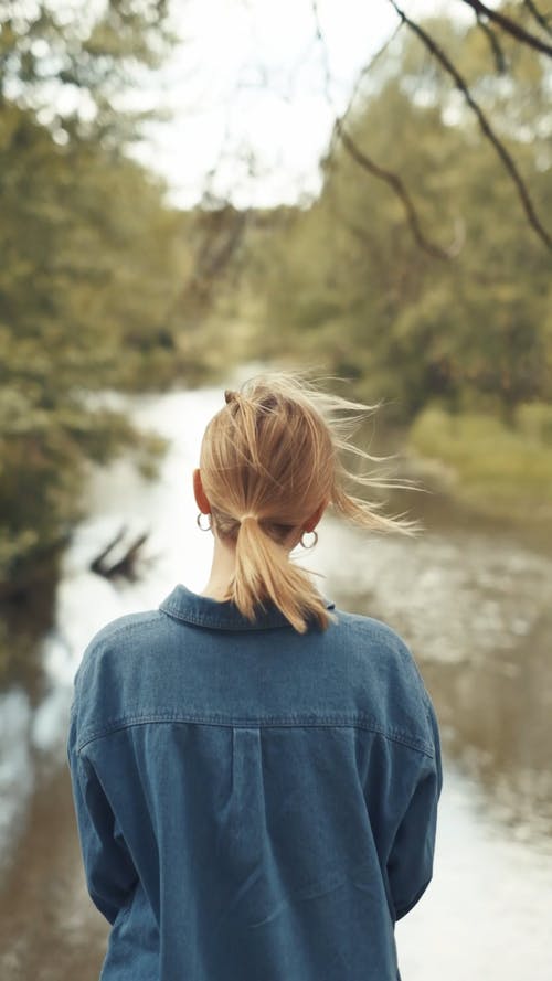 Back View of Woman in Denim Jacket Standing Outdoors