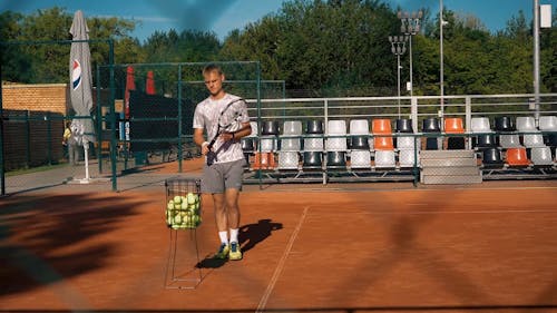 A Tennis Player Practicing His Serve