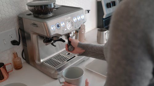 A Person Making Coffee with an Espresso Machine 