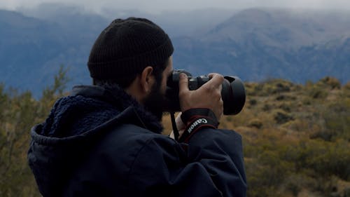 A Man Taking Photo Of The Mountains Scenery