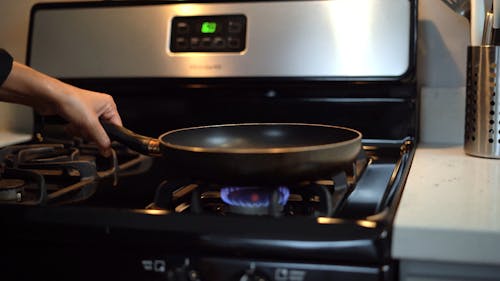A Person Putting a Pan on the Stove