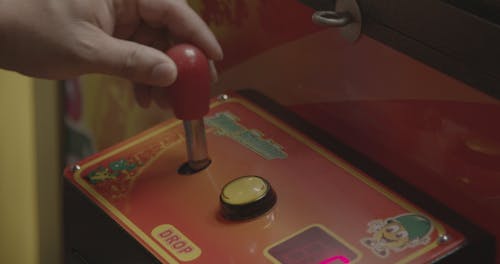 A Person Playing A Claw Game Machine