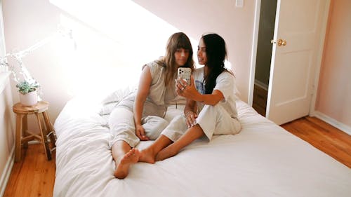 Two Women Video Chatting In Bed