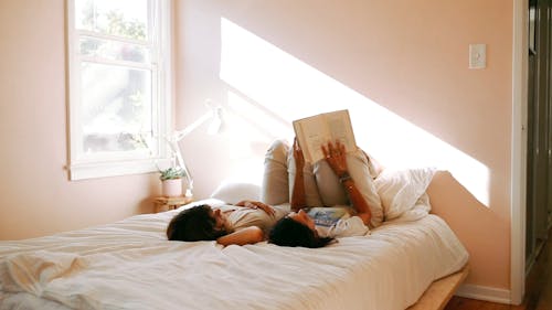 A Couple Reading A Book In Bed