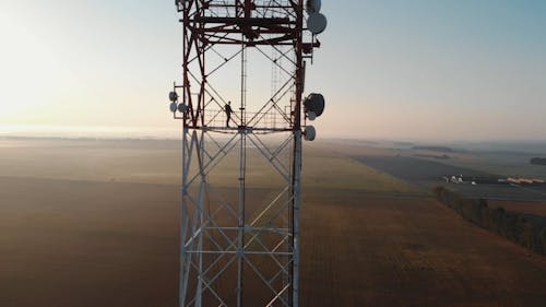 A Person Working On A High Communication Tower