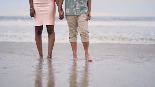 A Couple Walking In The Beach Holding hands