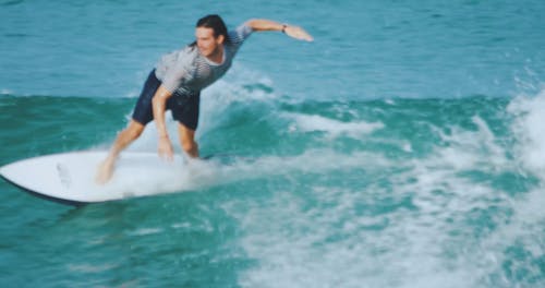 A Male Surfer Riding Skillfully The Sea Waves