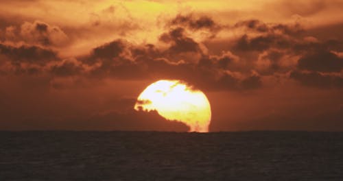 Person Surfing on the Sea at Sunrise