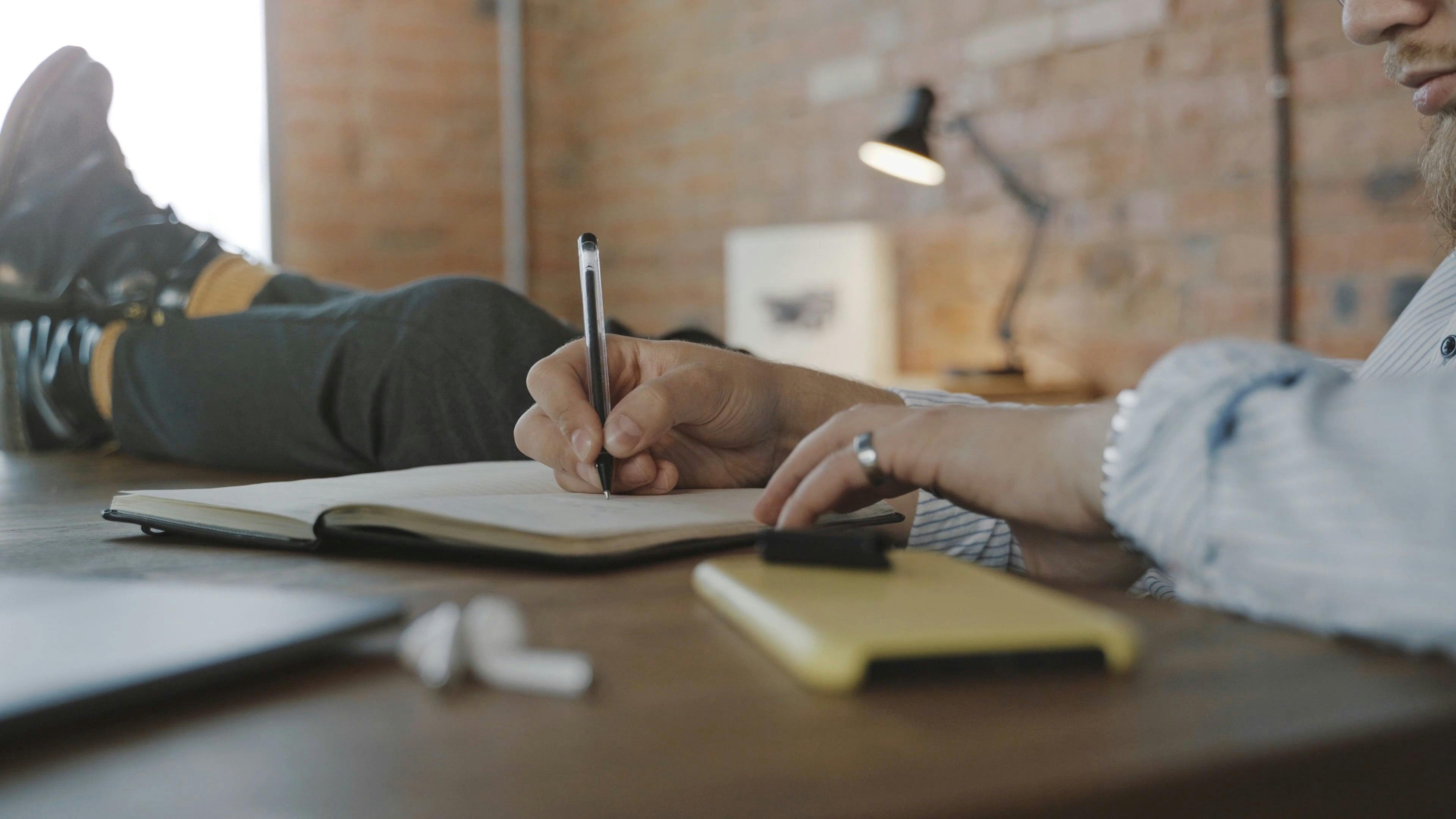 Writing on a Notebook · Free Stock Video