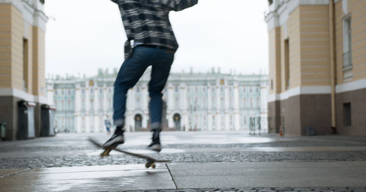 A man is walking down a sidewalk in front of a building Free Stock ...