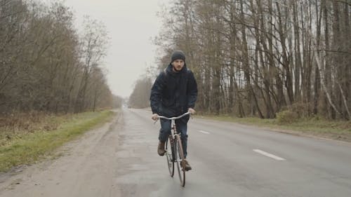 Man Riding a Bicycle in a Road