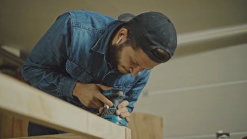 A Joiner Using a Grinding Machine to Smoothen the Wooden Surface