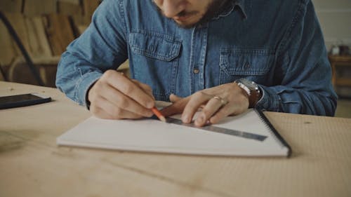 A Man Drawing a Plan on a Sketchpad