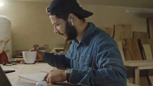 A Man Drinks His Coffee While Drawing His Design