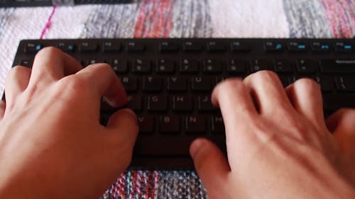 Close-Up View of a Person Typing Using a Keyboard