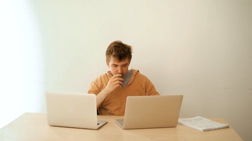 Man Using Laptops while Drinking Beverage