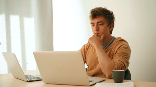 Man Using Laptops while Drinking Beverage